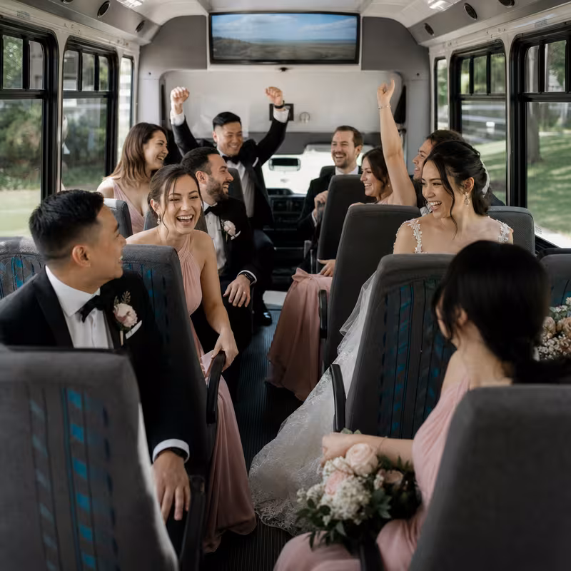 Group boarding a white charter bus for Wedding Transportation transportation in New York